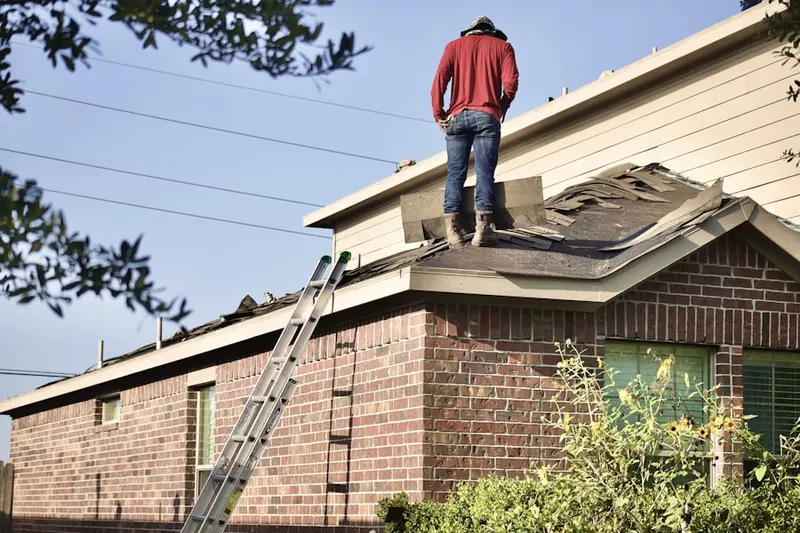 Professional roofer working on a residential roof in New Castle